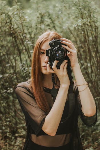 Woman Holding Black Dslr Camera Taking a Picture