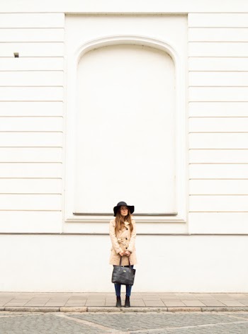 Woman Holding Black Leather Tote Standing Near Building's Wall