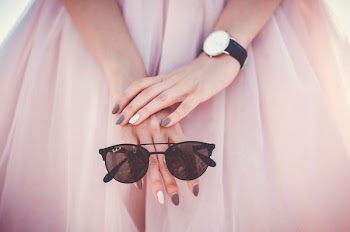 woman holding black Ray-Ban sunglasses