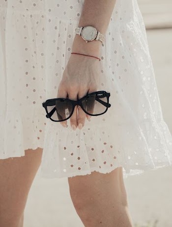 woman holding black sunglasses