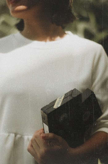 Woman Holding Black Vhs Tape