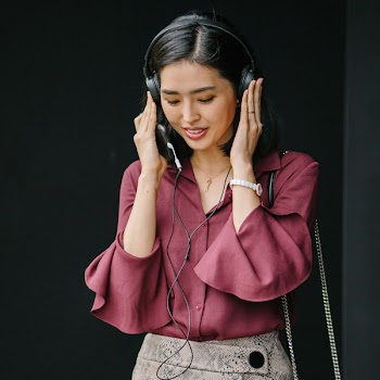 Woman Holding Black Wired Headphones