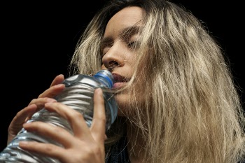 Woman Holding Blue Plastic Bottle