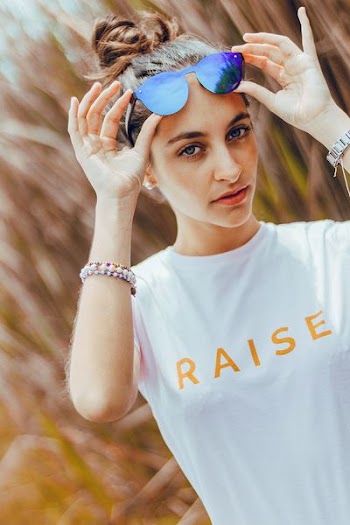 woman holding blue sunglasses