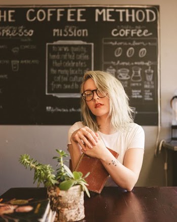 woman holding book by the table