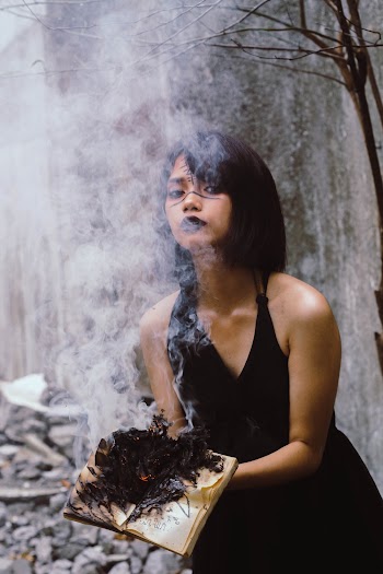 Woman Holding Book on Fire