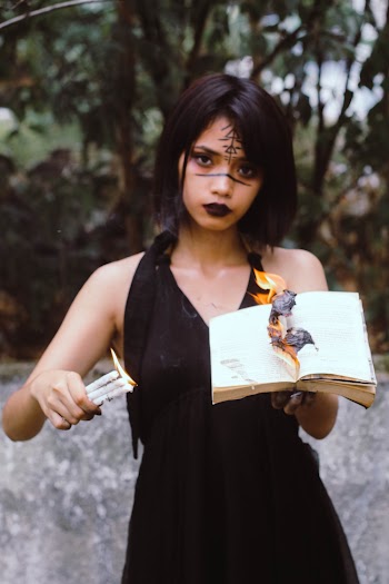 Woman Holding Book on Fire