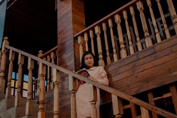 Woman Holding Book Standing on Staircase