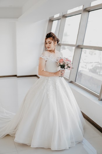 Woman Holding Bouquet of Flowers While Standing by the Window