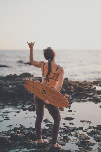 woman holding brown cruiser board