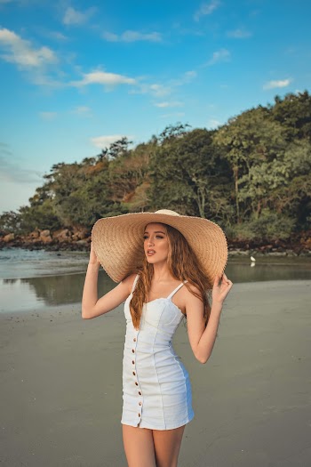 Woman Holding Brown Sun Hat on Head