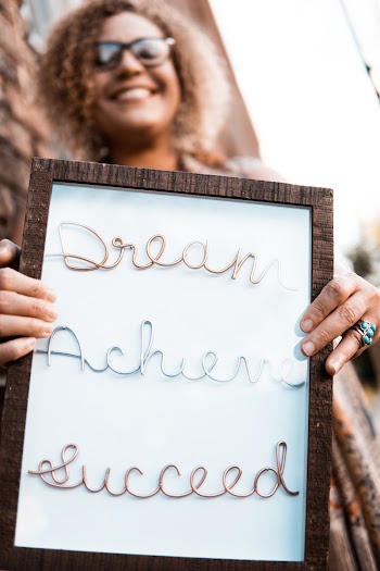 Woman Holding Brown Wooden Frame With Dream Achieve Succeed