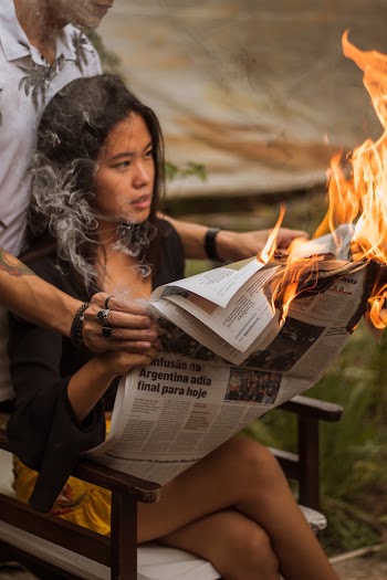 Woman Holding Burning Newspaper
