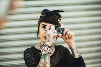 Woman Holding Camera in Front of Roll-up Door