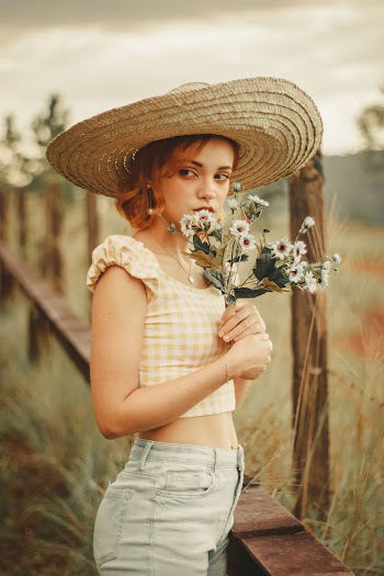 Woman Holding Chrysanthemum Flowers Close To Her Chest At The Farm