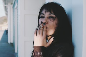 woman holding cigarette stick