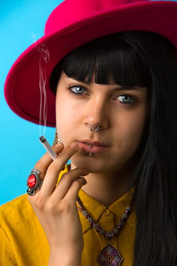Woman Holding Cigarette Stick Wearing Red Hat and Yellow Collared Button-up Shirt