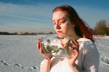 Woman Holding Clear Glass Bottle With Rose Inside