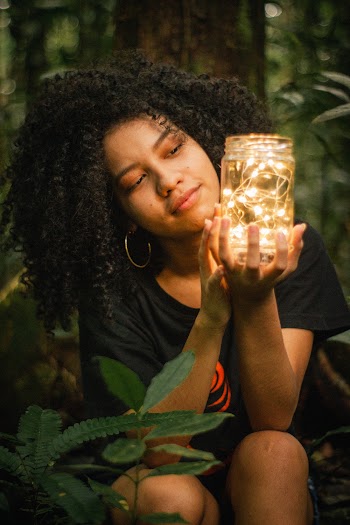 Woman Holding Clear Glass Jar Lamp Near Green-leafed Plant