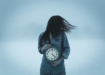 woman holding clock at 4:20