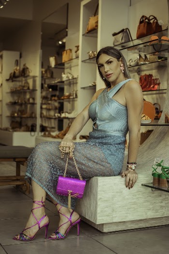 Woman Holding Clutch Bag Sitting on Chair