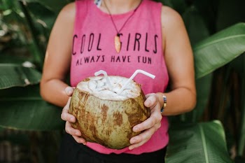 woman holding coconut with straw
