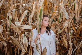 Woman Holding Corn on Cornfield