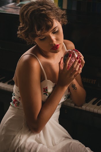 Woman Holding Crystal Ball Sitting Beside Piano