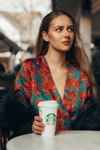 woman holding cup in front of white table