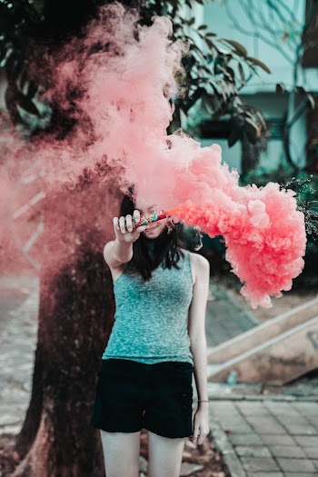 Woman Holding Device With Pink Smoke