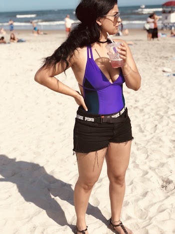 Woman Holding Disposable Cup With Straw in Seashore
