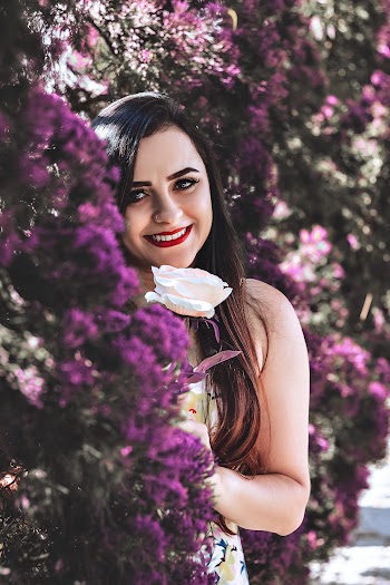 Woman Holding Flower Near Bush
