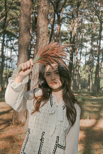 Woman Holding Flowers Near Trees