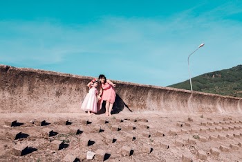 Woman Holding Girl Near Concrete Wall