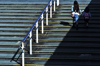 woman holding girl walking on stairs