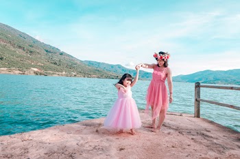 Woman Holding Girl While Standing on Cliff