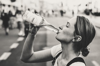 Woman Holding Glass Bottle in Grayscale Photo