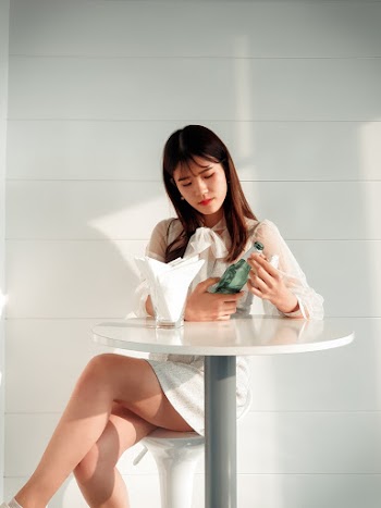 Woman Holding Glass Bottle Sitting