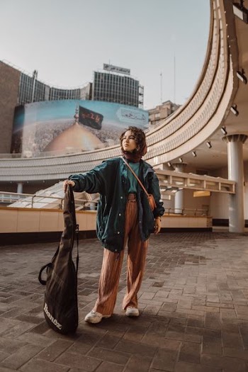 woman holding guitar bag