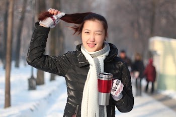 Woman Holding Hair and Red and Grey Travel Mug