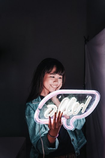 Woman Holding Hello Neon Signage