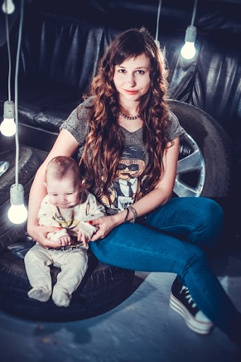 Woman Holding Her Baby Sitting On Tire