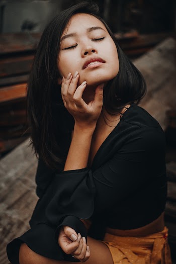 Woman Holding Her Chin While Closing Both Eyes