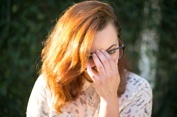 Woman Holding Her Eyeglasses While Sitting