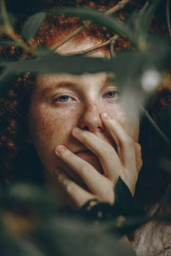 Woman Holding Her Face Beside Green-leafed Plants