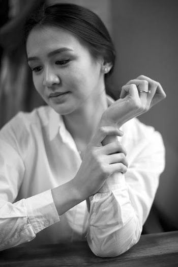 woman holding her forearm