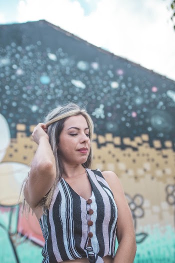 Woman Holding Her Hair in Front Painted Wall