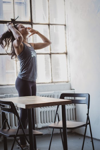 Woman Holding Her Hair Near Brown Wooden Table