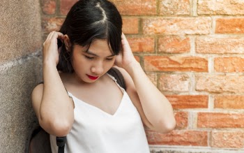 Woman Holding Her Hair While Standing on the Corner