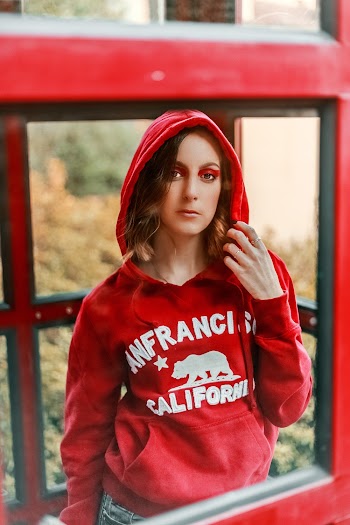 Woman Holding Her Hoodie Inside Phonebooth